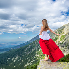 Young woman on the top of mountain