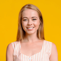 Young And Beautiful. Smiling Blonde Teen Girl Over Yellow Background