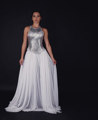 Fototapeta premium Pretty girl posing in a fashion dress over black background