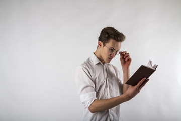 Young man holding workbook in his hands.