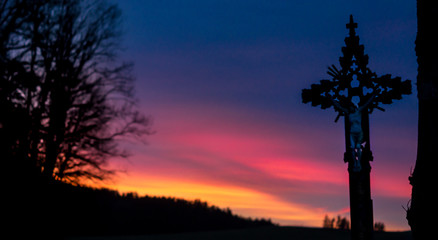 Farbenfroher Sonnenuntergang mit Jesuskreuz