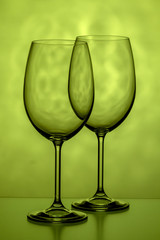 Two glasses for wine on a yellow-green background