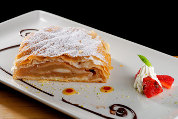 Traditional pieces of apple strudel with cinnamon,raisin, powdered sugar