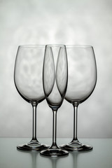 Three glasses of wine. One for champagne and two for wine on a light background.