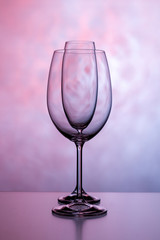 Two glasses for wine. One for champagne and one for wine on a purple background.