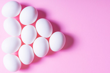 White egg on pink background. minimal concept. top view