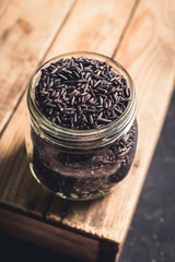 Raw black rice on the dark rustic background. Selective focus. shallow depth of field.