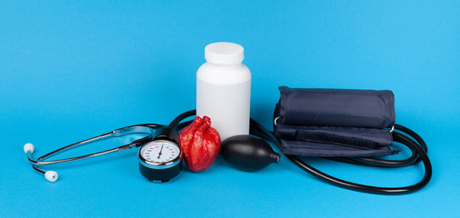 Heart and mechanical blood pressure monitor on a blue background. Measurement and control of blood...