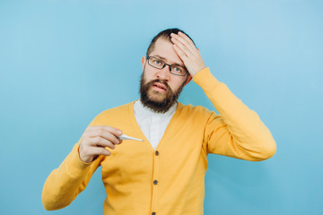 Naklejka premium The guy with the symptoms of a grit on a blue background. A man with a cough, a headache, a fever. Symptoms of coronavirus. COVID 2019 Epidemic
