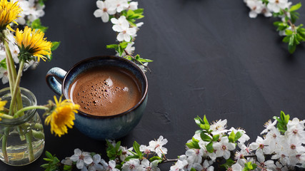 a mug of fragrant coffee on the table with spring blooming flowers copy space