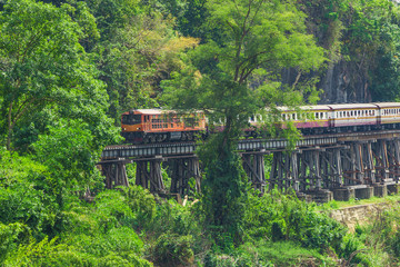 Fototapeta na wymiar World war II historic railway, known as the Death Railway with a lot of tourists on the train taking photos of beautiful views over Kwai Noi River. 