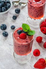 Mixed berry smoothie garnished with fresh fruit and mint