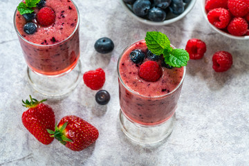 Mixed berry smoothie garnished with fresh fruit and mint