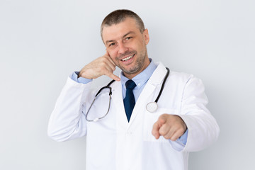 Portrait of mature doctor making call me gesture