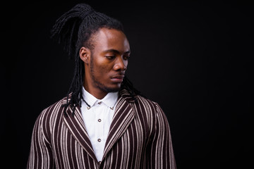 Face of young handsome African businessman in suit with dreadlocks