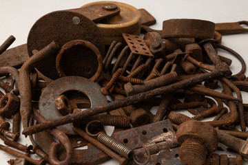 a mountain of various rusty metal construction parts on a white background