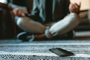 Man doing yoga meditation in office lounge