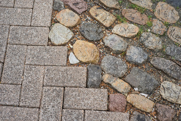 Closeup of modern concrete cobbles and vintage granit cobbles texture