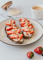 Rye Bread Toasts with Ricotta, Strawberries, Almond and Honey with coffee on white background