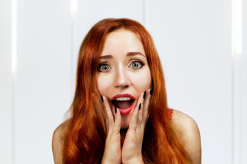 Shocked and surprised girl screaming. Curly ginger hair woman amazed with open mouth. Expressive facial expressions
