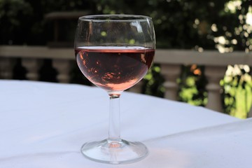 Verre de vin rosé dans un verre ballon transparent sur une nappe blanche - Département du Rhône - France