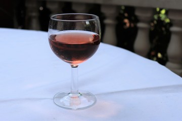 Verre de vin rosé dans un verre ballon transparent sur une nappe blanche - Département du Rhône - France