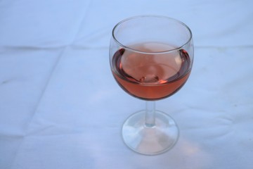 Verre de vin rosé dans un verre ballon transparent sur une nappe blanche - Département du Rhône - France