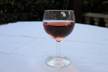 Verre de vin rosé dans un verre ballon transparent sur une nappe blanche - Département du Rhône - France