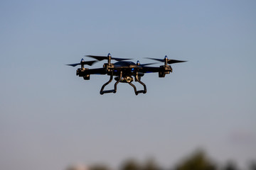 Flying Drone with camera against blue sky close up