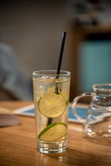 Glass lemonade lime coctail cold drinks fresh fruits table cafe restaurant  bokeh