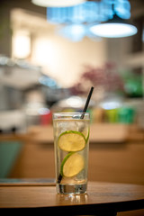 Glass lemonade lime coctail cold drinks fresh fruits table cafe restaurant  bokeh