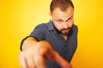 Hey you concept. Close up portrait of charismatic 35 years old man standing over yellow background...