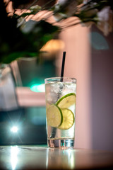 Glass lemonade lime coctail cold drinks fresh fruits table cafe restaurant  bokeh