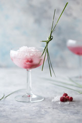 Pink mocktail close up. Beverage with rose and prosecco wine in drinkware. Exotic French Martini cocktail portion with crushed ice in glassware