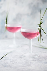 Pink mocktail close up. Beverage with rose and prosecco wine in drinkware. Exotic French Martini cocktail portion with crushed ice in glassware