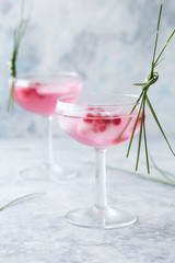 Pink mocktail close up. Beverage with rose and prosecco wine in drinkware. Exotic French Martini cocktail portion with crushed ice in glassware