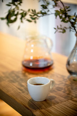 Black filter coffee on the table in cafe service kettle hario pour over cup flowers