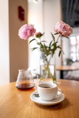 Fototapeta na wymiar Black filter coffee on the table in cafe service kettle hario pour over cup flowers