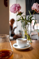 Black filter coffee on the table in cafe service kettle hario pour over cup flowers