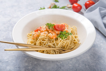spagetti marinara with shripms.  pasta dish on grey concrete  table