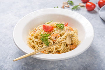 spagetti marinara with shripms.  pasta dish on grey concrete  table