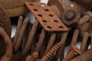 a mountain of various rusty metal construction parts on a white background. Selective focus