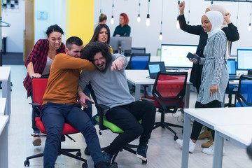 Fototapeta premium Group of Creative office workers collaborate together making joke with each other during their work inside office. Succes and competition business concept