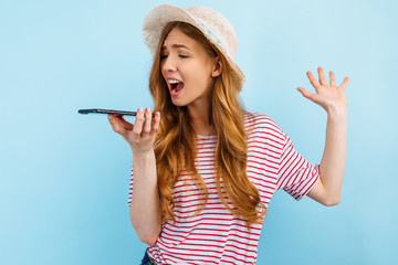Aggressive annoyed girl screaming at a smartphone, screaming nervously and talking on the phone, on...