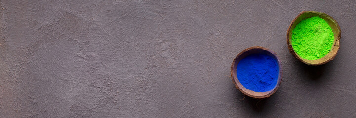 Blue and green paint in coconut peel on gray background