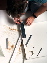 Man doing renovation work at home, drilling with a screwdriver. Group of repair tools on wooden...