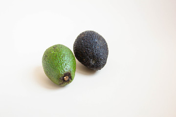 Bad and good avocado close-up on a white background. Concept for dealing with missing tropical products