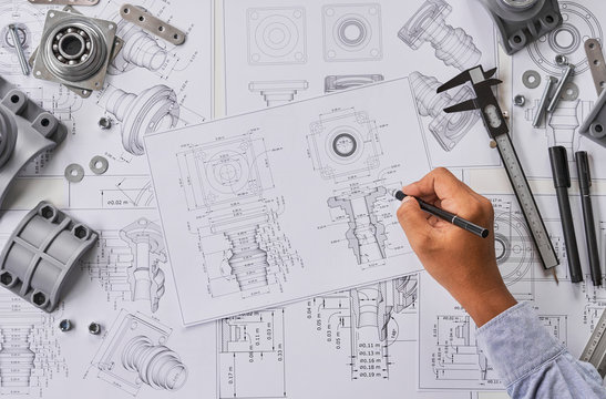 Engineer technician designing drawings mechanical parts engineering Engine.manufacturing factory Industry Industrial work project blueprints measuring bearings caliper tools