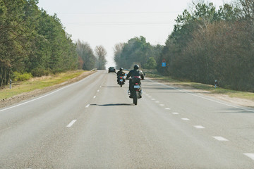 Motorcyclists are moving along the road