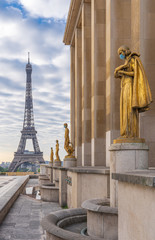 Paris, France - 05 06 2020: Golden statue of a woman wearing a surgical mask during confinement against coronavirus and the eiffel tower